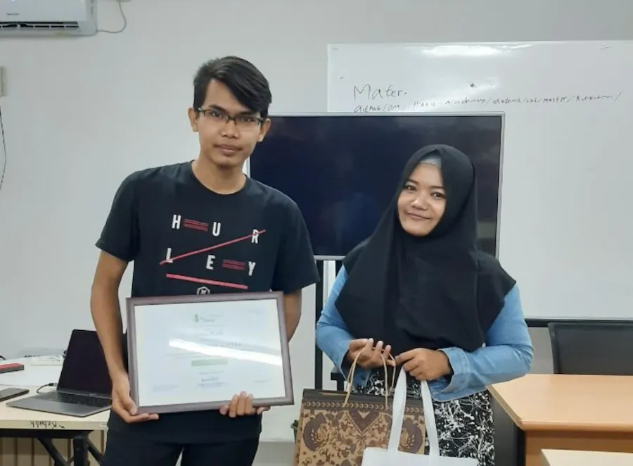 Pengurus komunitas surabayadev membagian merchandise kepada pengisi acara